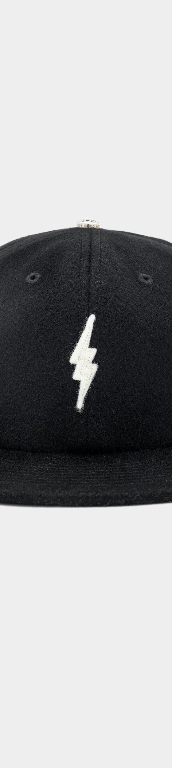 A black wool GOOD ART HLYWD cap with a white lightning bolt embroidery