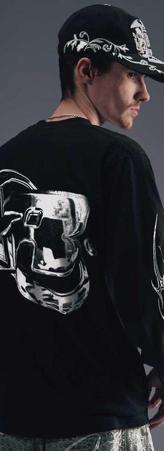 A man wearing a black Greedy Unit long-sleeve tee and printed cap, photographed from behind