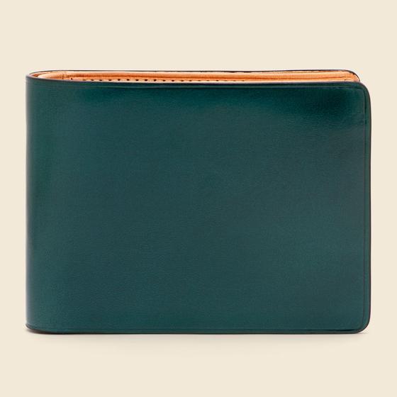 A dark green Il Bussetto hand-dyed leather bifold wallet with natural tan interior