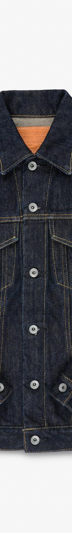 An Iron Heart indigo selvedge denim trucker jacket on a plain white background