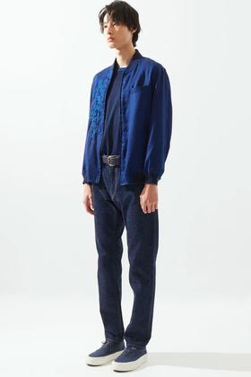 A man wearing an indigo Japan Blue bomber jacket over a navy tee with dark selvedge denim jeans