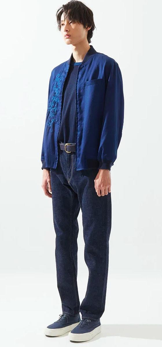 A man wearing an indigo Japan Blue bomber jacket over a navy tee with dark selvedge denim jeans