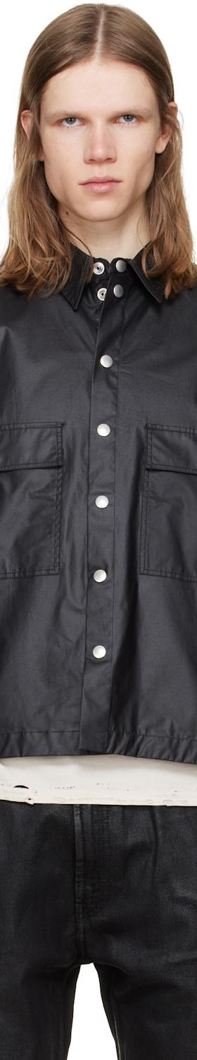 A man wearing a black coated cotton overshirt with snap-front closure
