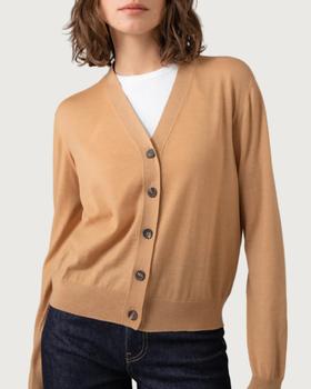 A woman wearing a camel Johnstons of Elgin superfine merino cardigan with dark denim jeans