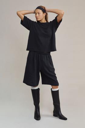 A woman wearing a navy Jungmaven hemp boxy tee and matching long shorts