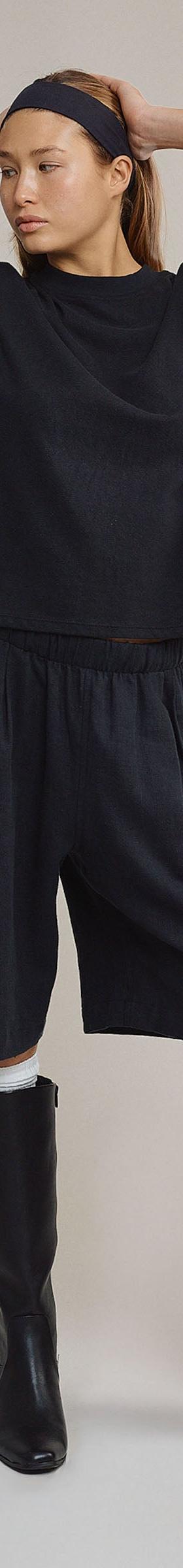 A woman wearing a navy Jungmaven hemp boxy tee and matching long shorts