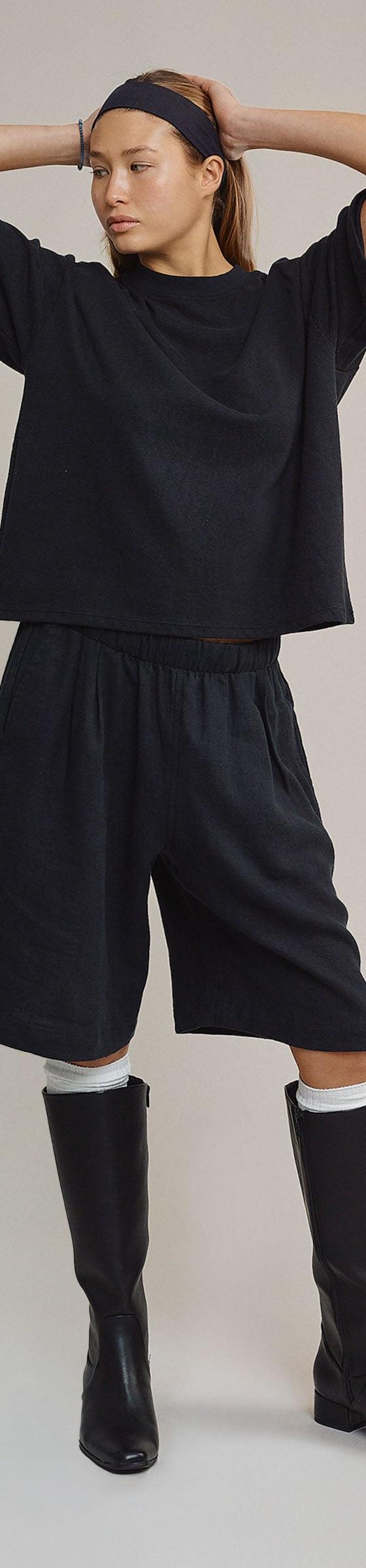 A woman wearing a navy Jungmaven hemp boxy tee and matching long shorts