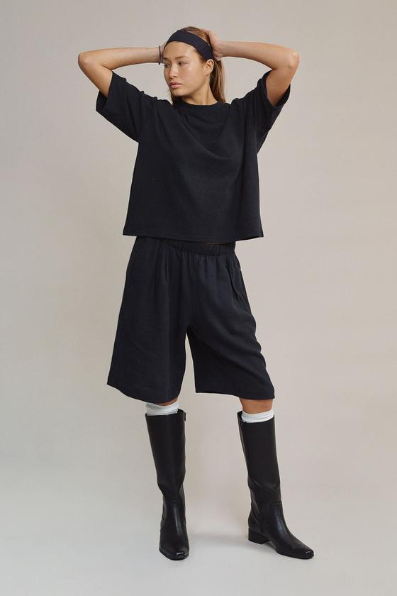 A woman wearing a navy Jungmaven hemp boxy tee and matching long shorts