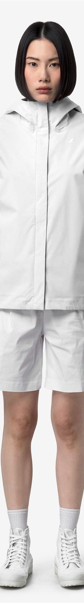 A woman wearing a white K-Way hooded windbreaker jacket with matching shorts