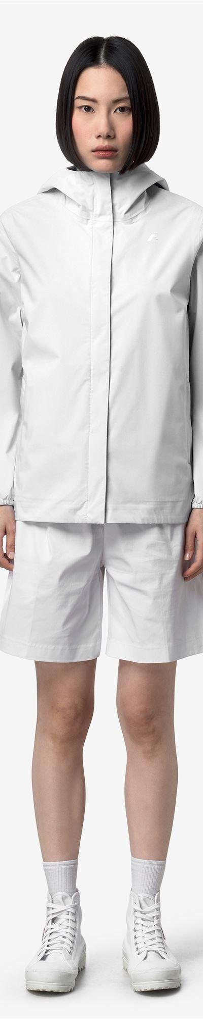A woman wearing a white K-Way hooded windbreaker jacket with matching shorts