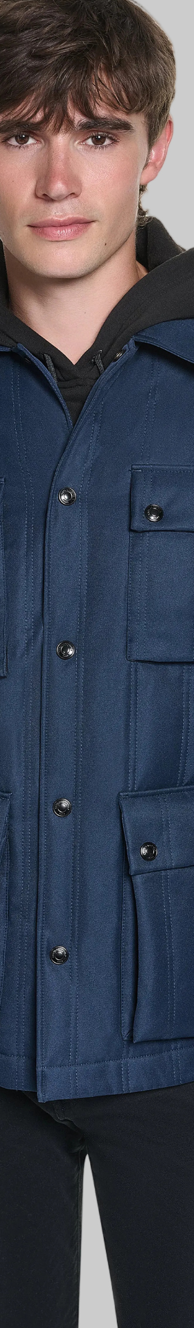 A man wearing a navy Karl Lagerfeld Paris four-pocket field jacket with black trousers