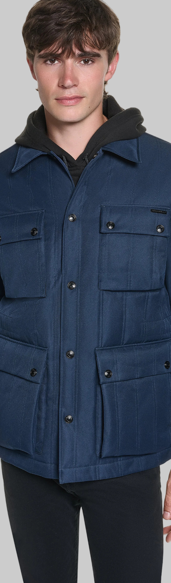 A man wearing a navy Karl Lagerfeld Paris four-pocket field jacket with black trousers