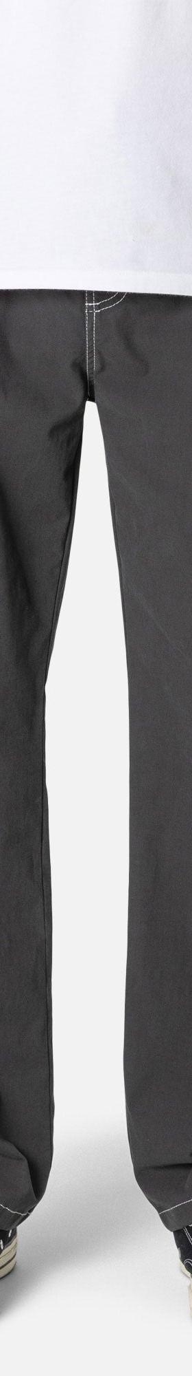 A man wearing charcoal Katin canvas work pants with a white tee and sneakers