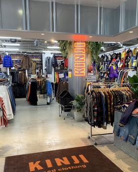 KINJI Harajuku interior: KINJI doormat, packed racks of vintage jackets and sportswear, neon KINJI sign