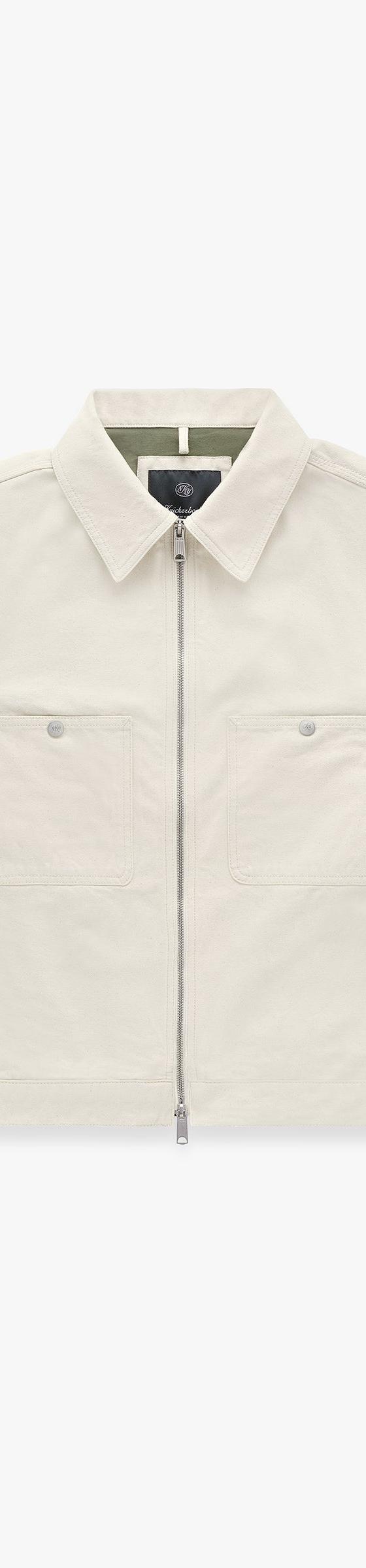 An off-white Knickerbocker zip-front work jacket with flap chest pockets on a plain background