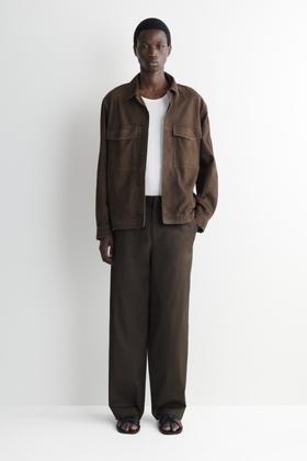 A man wearing a brown suede overshirt with matching wide-leg trousers