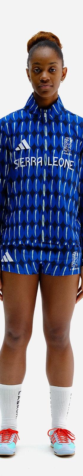 A woman wearing a blue patterned Labrum London tracksuit jacket and shorts