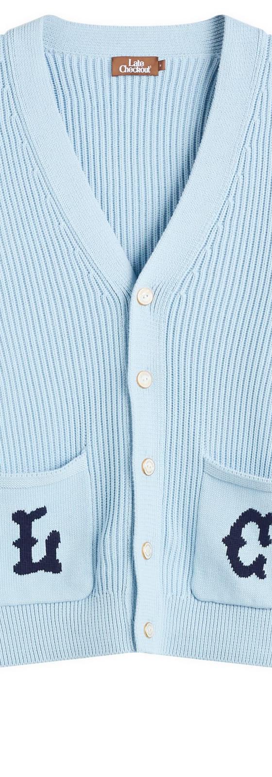 A pale blue Late Checkout ribbed knit cardigan with navy lettered patch pockets