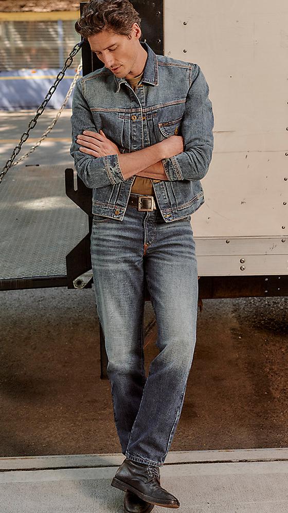 A man wearing a Lee denim trucker jacket and straight-leg jeans