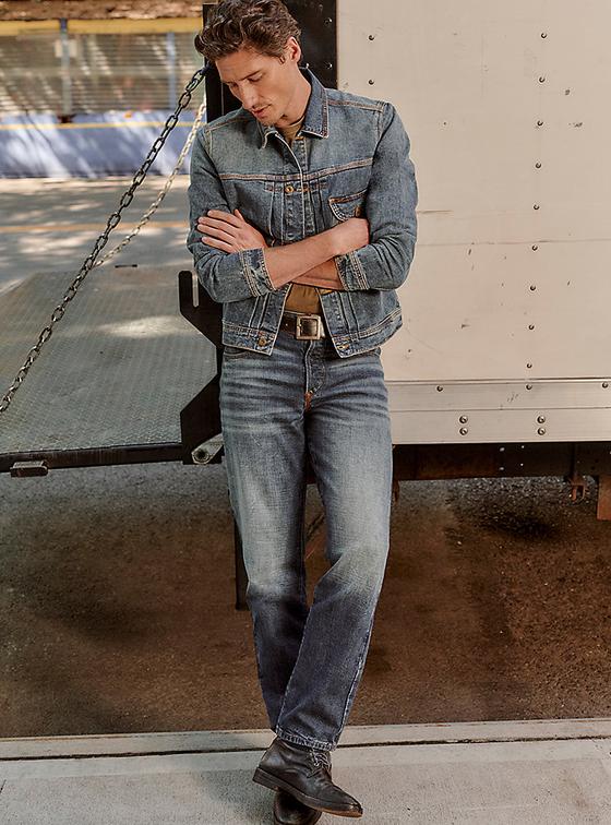 A man wearing a Lee denim trucker jacket and straight-leg jeans