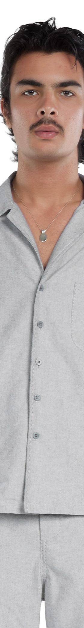 A man wearing a grey Les Tien short-sleeve camp collar shirt and matching trousers