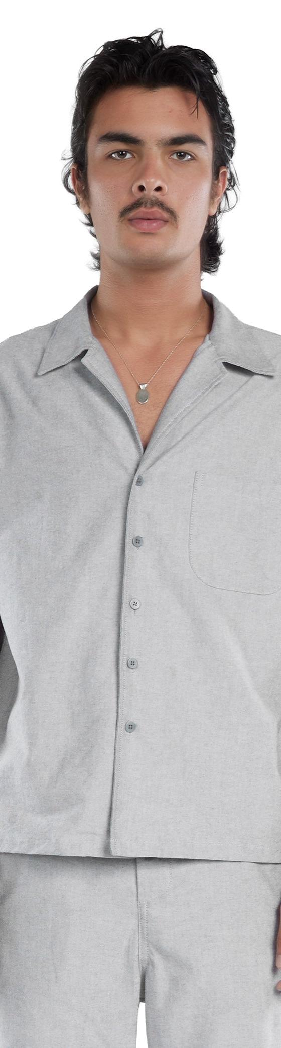 A man wearing a grey Les Tien short-sleeve camp collar shirt and matching trousers