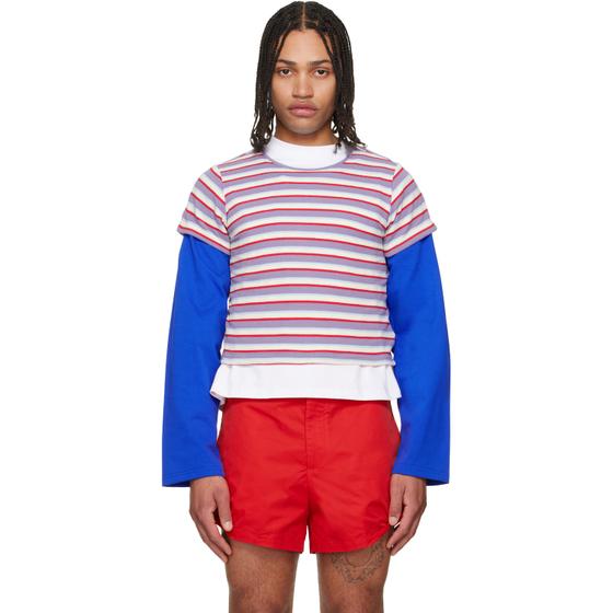 A man wearing a striped LII layered top with blue sleeves and red shorts