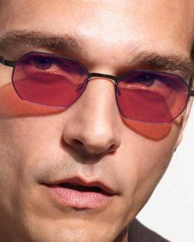 A man wearing LINDBERG rimless sunglasses with rose-tinted lenses