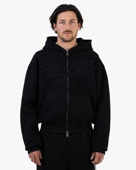 A man wearing a black zip-up hoodie and matching black sweatpants