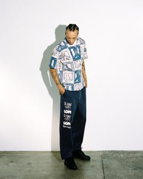 A man wearing a blue-printed Lo-fi camp-collar shirt with wide dark denim jeans