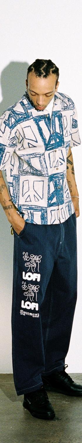 A man wearing a blue-printed Lo-fi camp-collar shirt with wide dark denim jeans