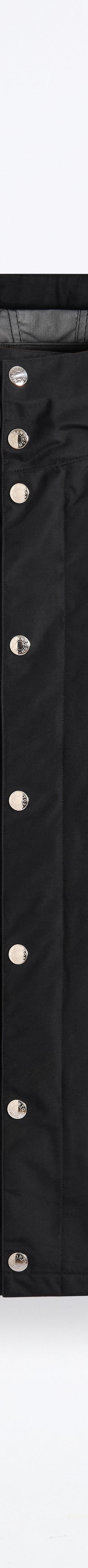 A black Mackintosh hooded raincoat with press-stud fastening on a plain white background
