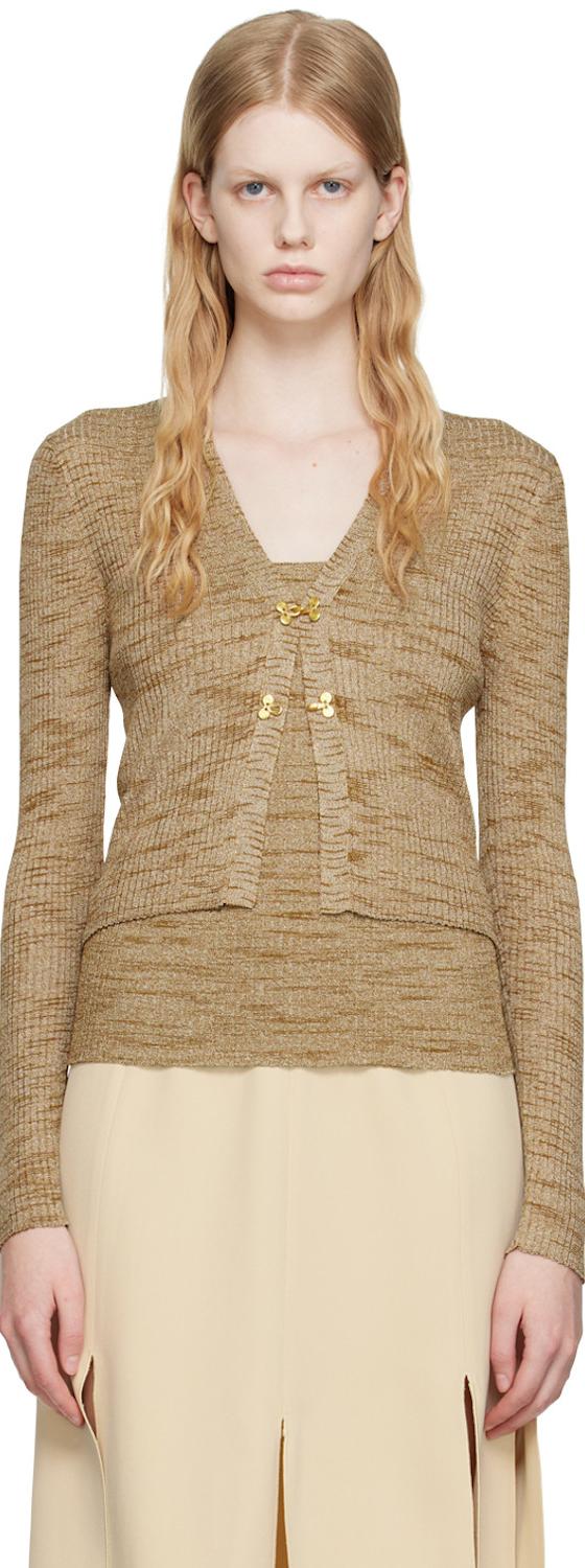 A woman wearing a beige marled knit cardigan and matching camisole with a cream slit skirt by Maiden Name