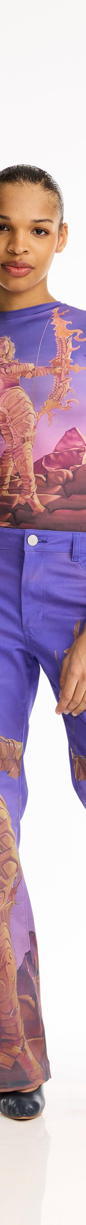 A woman wearing a purple Maisie Wilen printed top and matching printed trousers