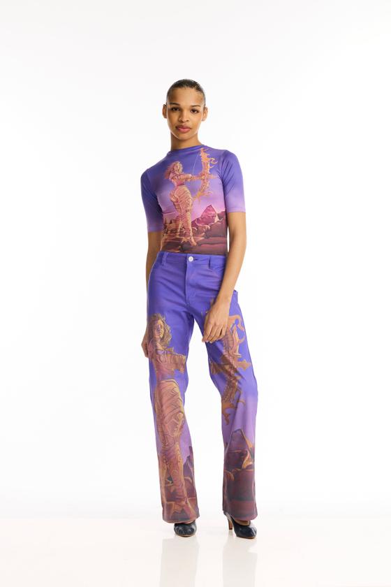 A woman wearing a purple Maisie Wilen printed top and matching printed trousers