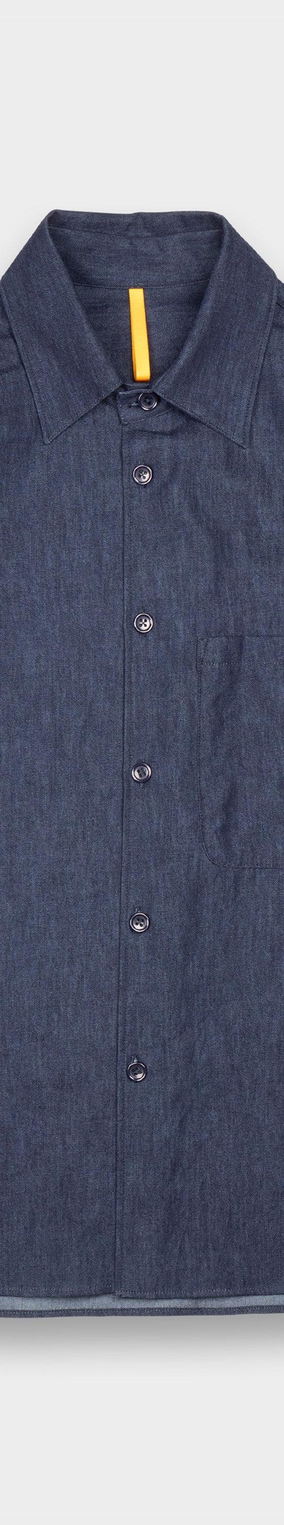 A dark indigo MAN-TLE button-up shirt with a chest pocket, shown on a plain light grey background