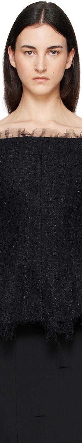 A woman wearing a black off-shoulder tulle-trimmed Matières Fécales top with a black skirt