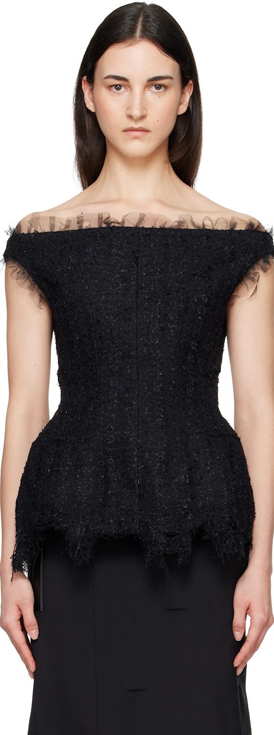 A woman wearing a black off-shoulder tulle-trimmed Matières Fécales top with a black skirt