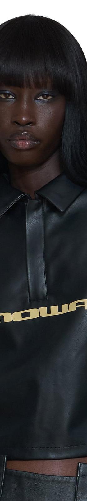A woman wearing a black leather Mawalola cropped polo top