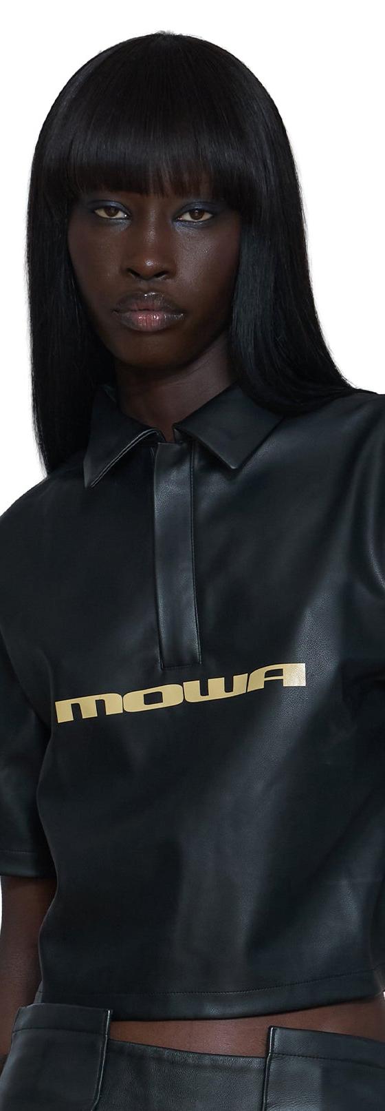 A woman wearing a black leather Mawalola cropped polo top
