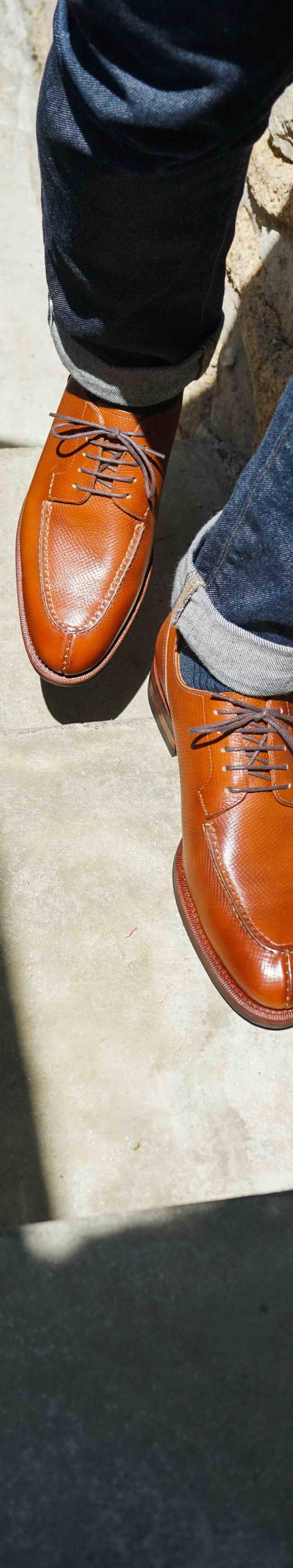 A man wearing tan leather Meermin derby shoes with cuffed dark denim