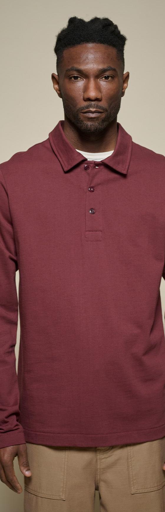 A man wearing a burgundy Merz b. Schwanen long-sleeve knit polo with tan trousers