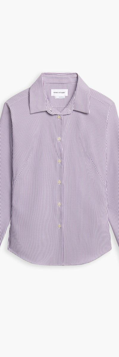 A striped Ministry of Supply performance dress shirt on a plain white background