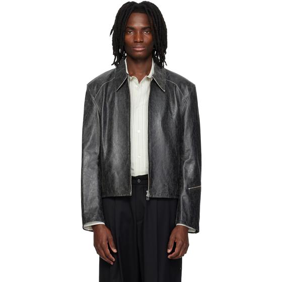 A man wearing a distressed grey leather jacket over a striped shirt and black wide-leg trousers