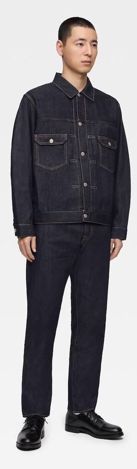 A man wearing a raw indigo Momotaro Jeans denim jacket and matching selvedge jeans