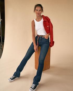 A woman wearing MOTHER Denim bootcut jeans with a white tank and red denim jacket