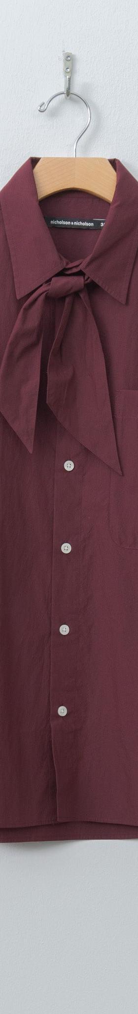 A burgundy Nicholson & Nicholson tie-neck cotton shirt on a hanger