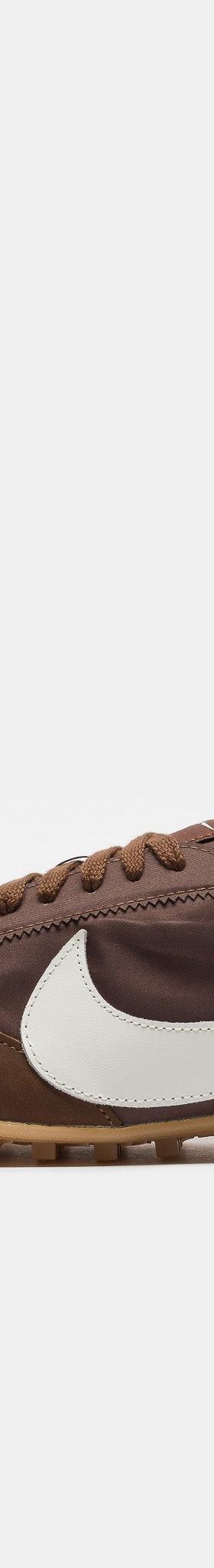 A brown suede and nylon Nike sneaker with a cream swoosh and gum sole