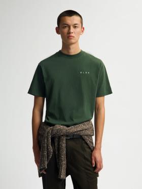 A man wearing a dark green ØLÅF t-shirt with a knit sweater tied around his waist