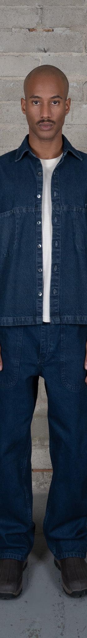 A man wearing an indigo-dyed Olderbrother denim overshirt and matching wide-leg jeans